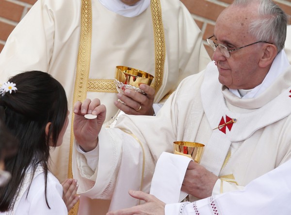 Pope Francis gives first Communion to girl during Mass at Sts. Elizabeth and Zechariah Parish on outskirts of Rome